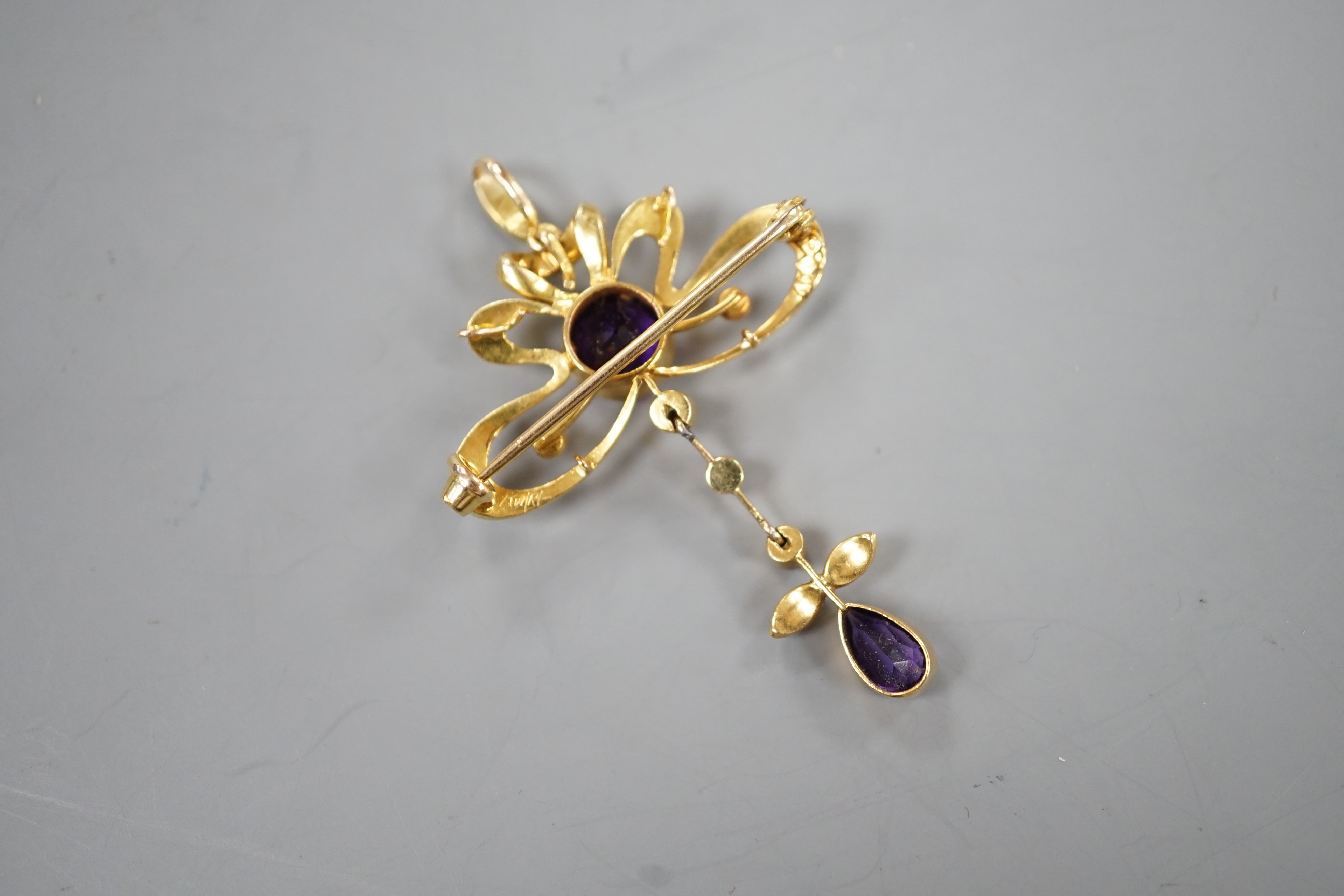 An Edwardian 15ct, amethyst and seed pearl set drop pendant brooch, overall 49mm, gross weight 5.3 grams.